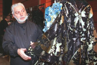 (FILES) In this file photo taken on January 20, 1999, Spanish Designer Paco Rabanne checks a dress before his 1999 Spring/Summer haute-couture collection, in Paris. - Spanish fashion designer Paco Rabanne, known for his eccentric clothing designs and for founding one of the worlds best-known fragrance brands, died on Friday at the age of 88. Rabannes death was confirmed to AFP by the parent company of his brand, who said he had marked generations with his radical vision of fashion and his legacy will live on. (Photo by Frederick FLORIN / AFP)<!-- NICAID(15339510) -->