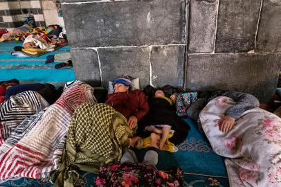 People rest in the historical Grand Mosque, where they found refuge, two days after a strong earthquake struck the region, in the southeastern Turkish city of Diyarbakir on February 8, 2023. - Many have taken refuge from relentless aftershocks, cold rain and snow in mosques, schools and even bus shelters -- burning debris to try to stay warm, after the earthquake, which is the largest Turkey had seen since 1939. (Photo by FULYA OZERKAN / AFP)<!-- NICAID(15343668) -->