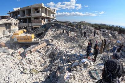 Rescue workers look for survivors amid the rubble of a building in the rebel-held town of Jindayris on February 10, 2023, days after an earthquake hit Turkey and Syria. - The 7.8-magnitude quake early on February 6 has killed more than 20,000 people in Turkey and war-ravaged Syria, according to officials and medics in the two countries, flattening entire neighbourhoods. (Photo by Rami al SAYED / AFP)<!-- NICAID(15345640) -->